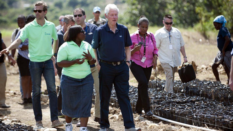 Bill Clinton (C) tours a Clinton Foundation project in Mirebalais, in the central plateau of Haiti, on 23 February 2015