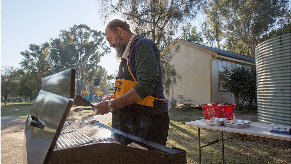 A volunteer cooks an election-day "sausage sizzle" in western Sydney