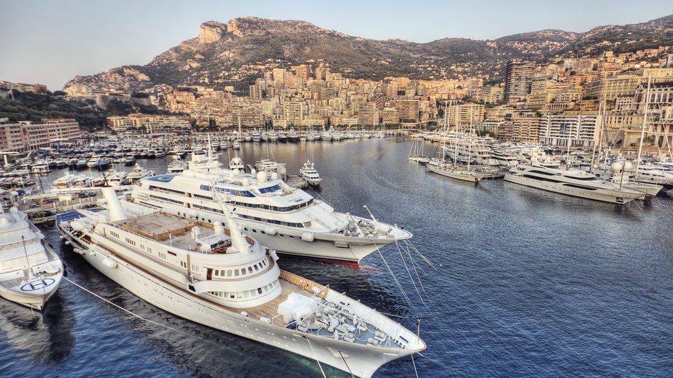 A wide shot showing a number of yachts sitting in the famous port of Monte Carlo just after sunrise.
