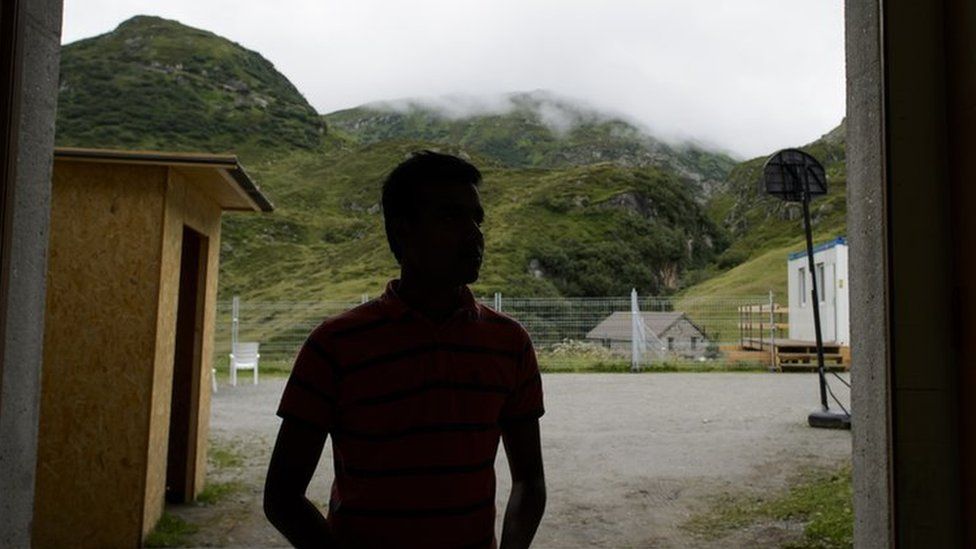 The silhouette of an asylum seeker at the entrance of a military bunker in the remote Alpine village of Realp, central Switzerland, in 2013