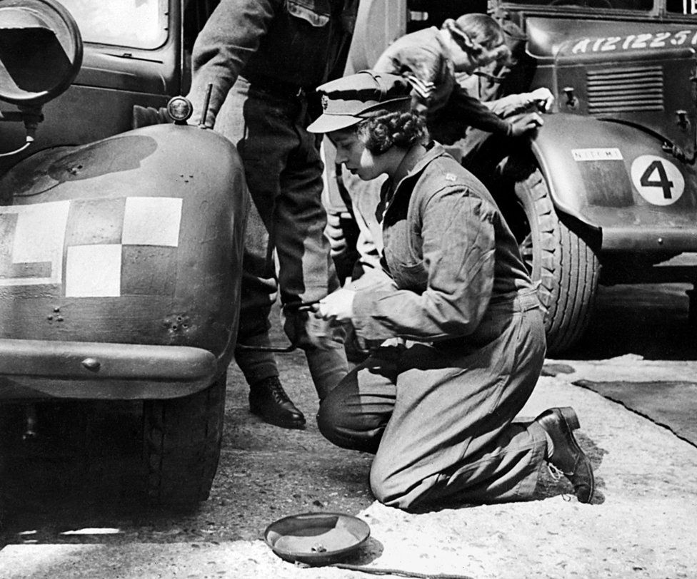 Princess Elizabeth changing the wheel of a military vehicle during World War Two, in an unknown location. 1940s