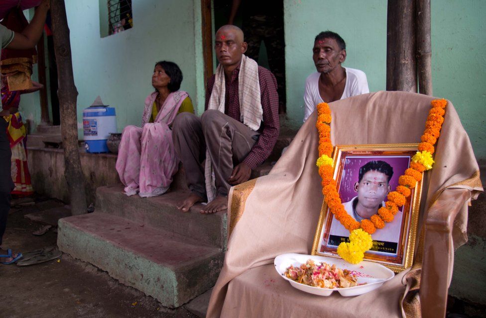 Pravin Soyam's family sit next to a photograph of him