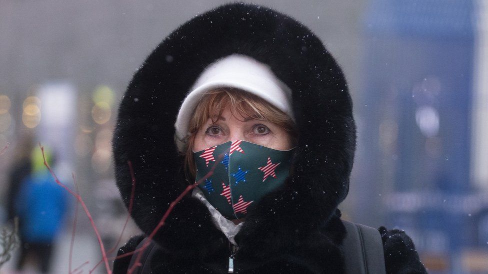 Женщина посещает Таймс-сквер во время снегопада во время зимней бури в Нью-Йорке