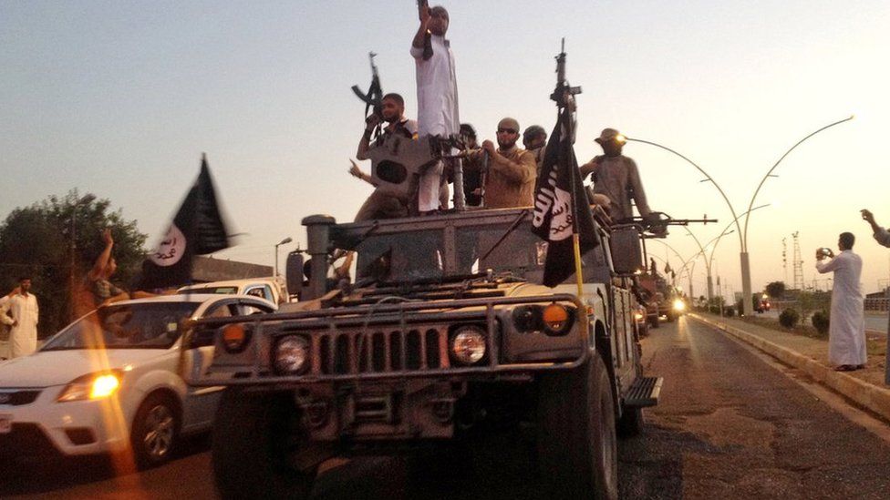 Islamic State in Iraq and the Levant (Isis) militants drive through Mosul in a captured Humvee (23 June 2014)