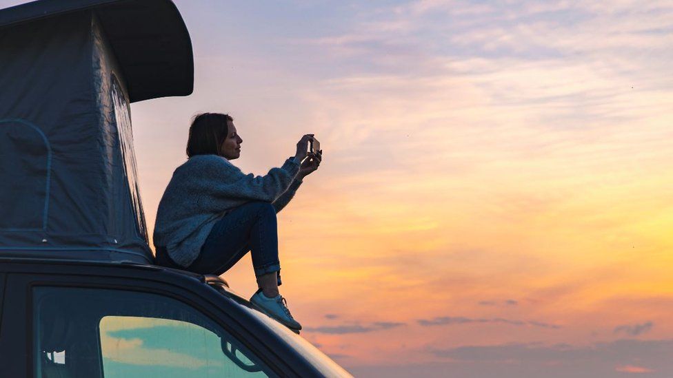 Woman sitting on a campervan