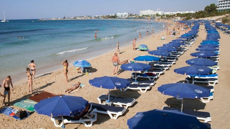 Stock photo of tourists sunbathing on a beach in the resort of Ayia Napa