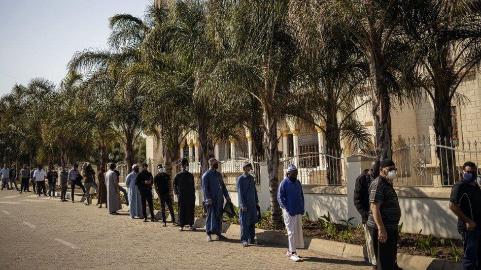 Muslims wearing masks as preventive measure against COVID-19 coronavirus await in line to enter the Nizamiye Mosque ahead of the Friday prayer in Midrand, Johannesburg, on June 5, 2020.