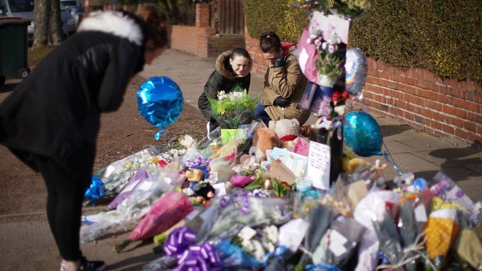 Photos, tributes and toys and flowers at the scene