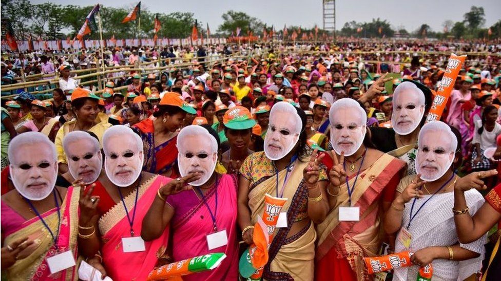 Сторонники правящей Индии Бхаратия Джаната Партия (БДП) в масках премьер-министра Нарендры Моди принимает участие в предвыборном митинге, на котором выступил Моди, в городе Моран в северо-восточном штате Ассам, Индия, 30 марта 2019 г.