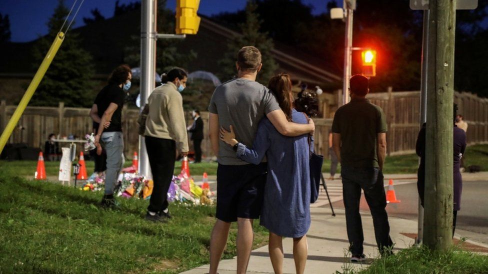 People react near flowers laid at the fatal crime scene in London, Ontario, Canada June 7, 2021
