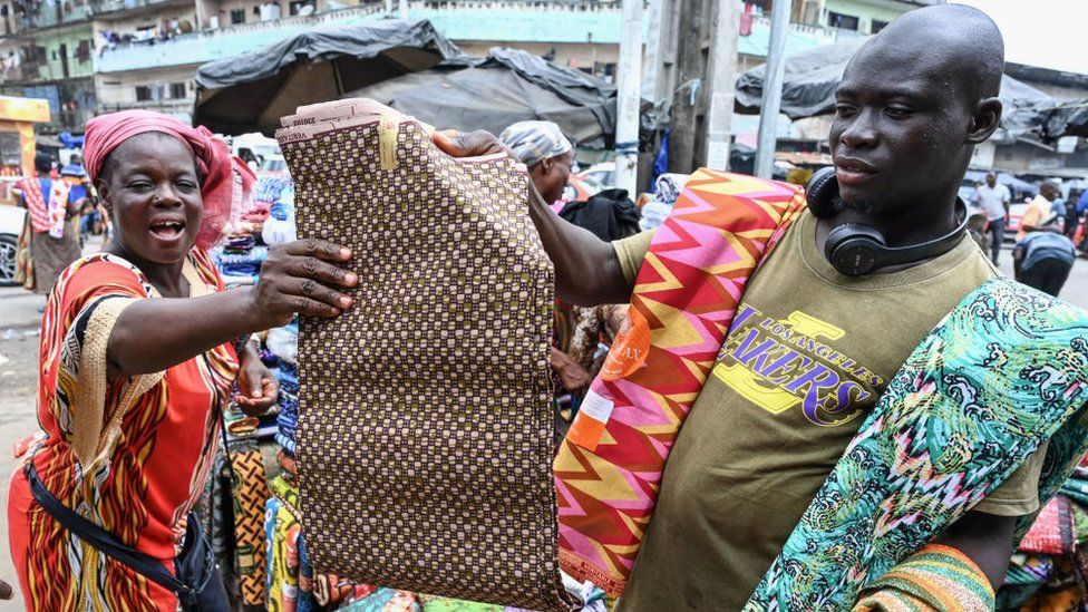 A vendor sells African wax print fabric at the Adjame main market in Abidjan on October 3, 2023.