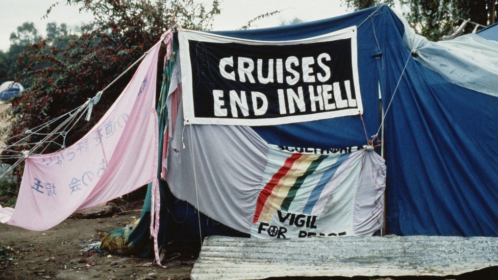 Cloth banners are seen outside a tent at Greenham Common peace camp, 1983