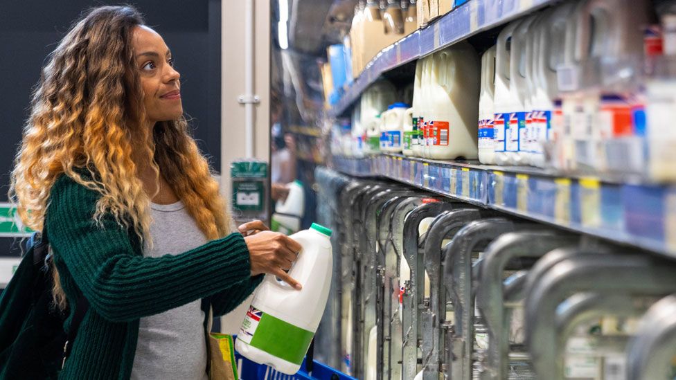 Woman buying milk in supermarket