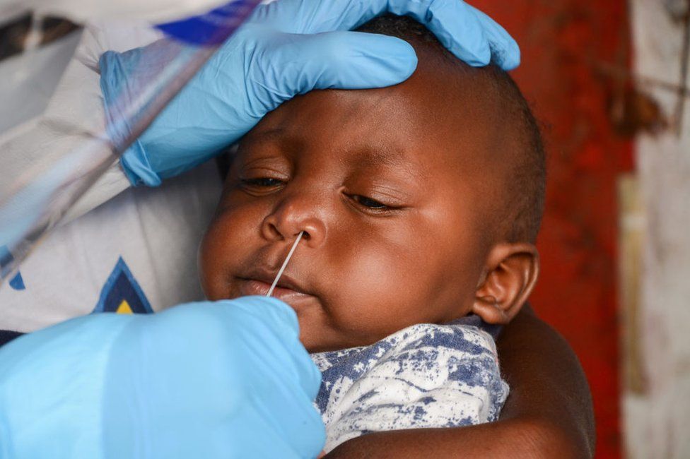 A health worker performs a nasal swab test on an infant in Nairobi, Kenya, in May 2020.