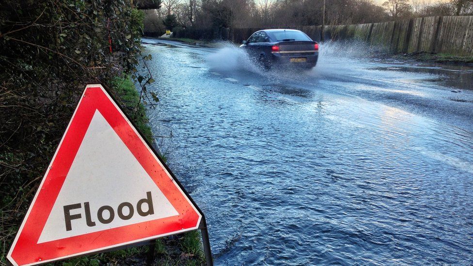 A car driving past a flood sign