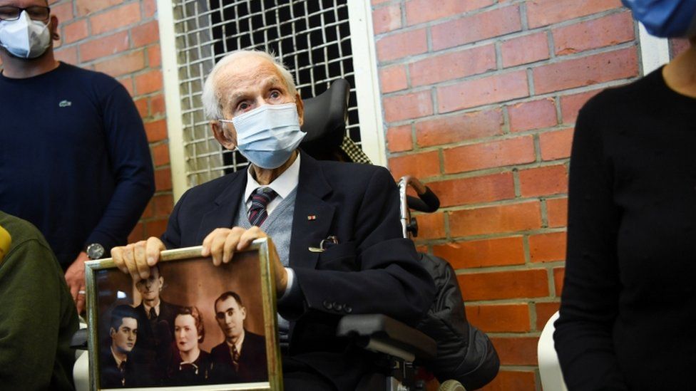 Holocaust survivor Leon Schwarzbaum holds a picture in the courtroom during a trial against a 100-year-old former security guard of the Sachsenhausen concentration camp, at the Landgericht Neuruppin court in Brandenburg, Germany, October 7, 2021