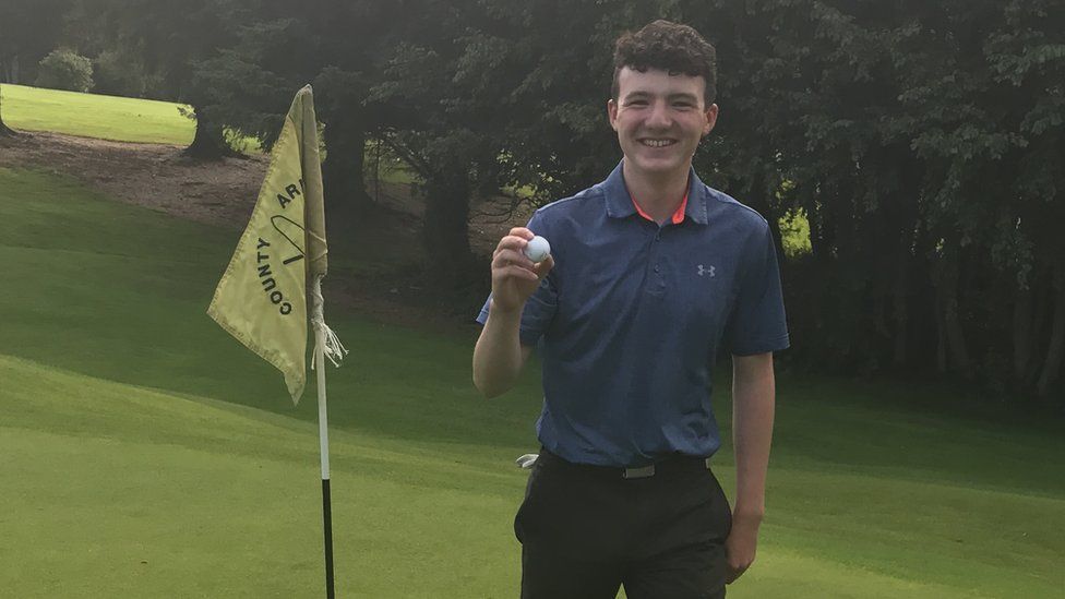 Joe Rooney holds his golf ball after scoring a hole-in-one