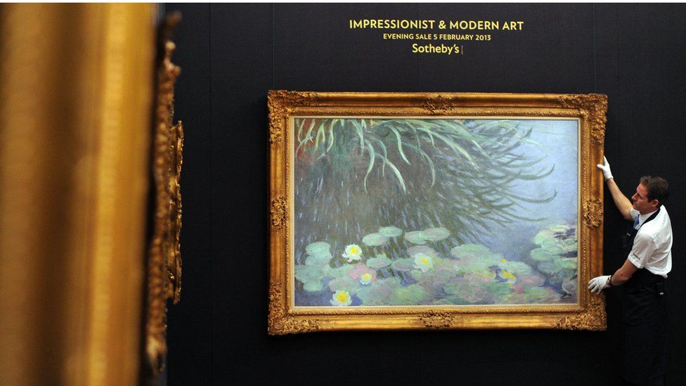 A member of staff poses with a painting entitled Nympheas Avec Reflets de Hautes Herbes by French artist Claude Monet at Sotheby's auction house in central London on 31 January 2013, and due to form part of the Impressionist and Modern Art Evening Sale on 5 February.