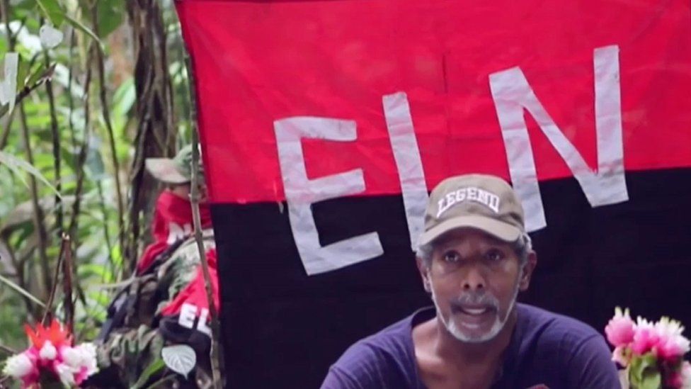 TV grab of Odin Sanchez in front of an ELN flag