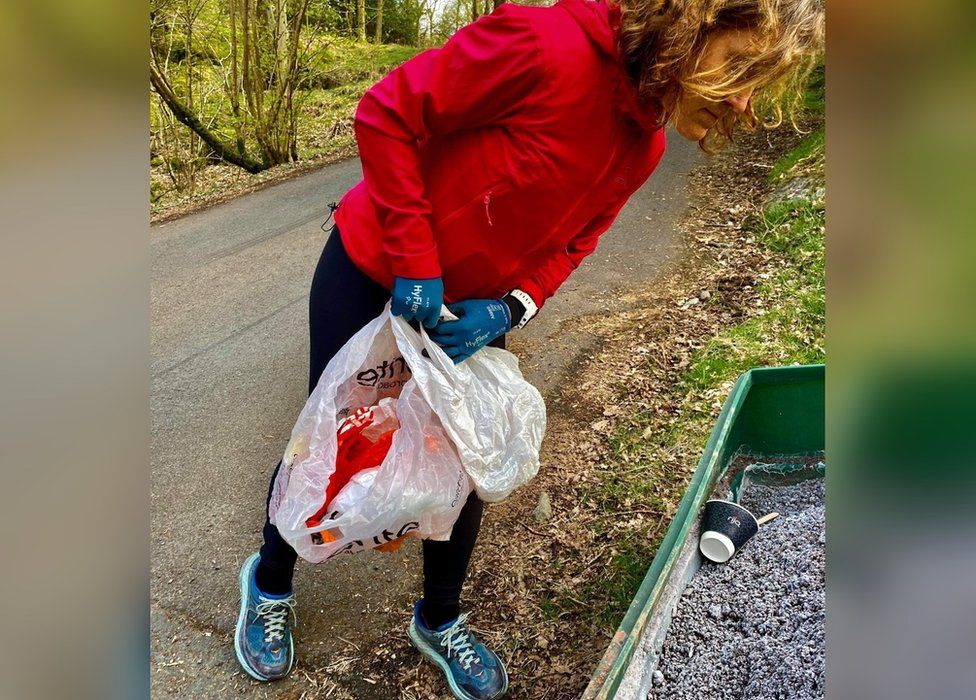 A volunteer collects rubbish