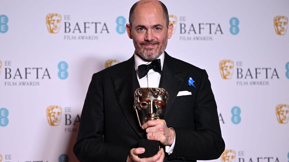 German movie director and screenwriter Edward Berger poses with the award for Best director for 'All Quiet on the Western Front' during the BAFTA British Academy Film Awards ceremony at the Royal Festival Hall, Southbank Centre, in London