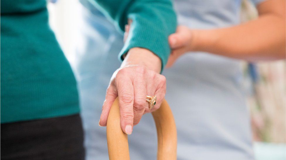 Woman helping elderly person