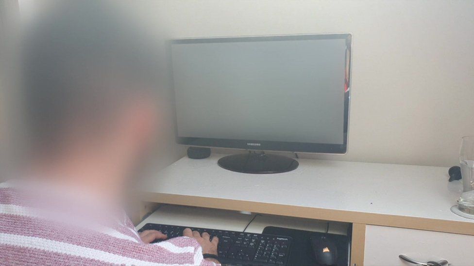 Contact tracer sat at his computer, his head is blurred as he wanted to remain anonymous