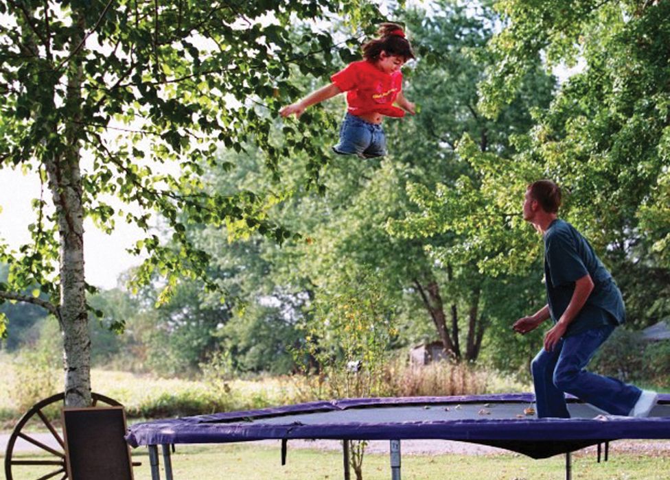 Jennifer bounces on the trampoline with her brother