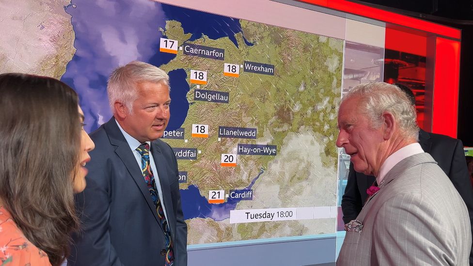 Charles standing in front of a weather map of wales