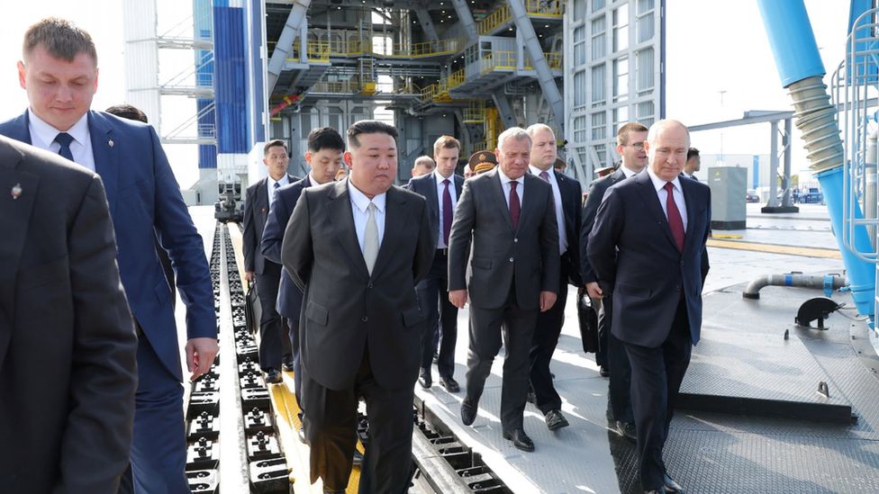 Kim Jong Un and Vladimir Putin are followed by their delegations as they tour a space launch site at Vostochny Cosmodrome on 13/9