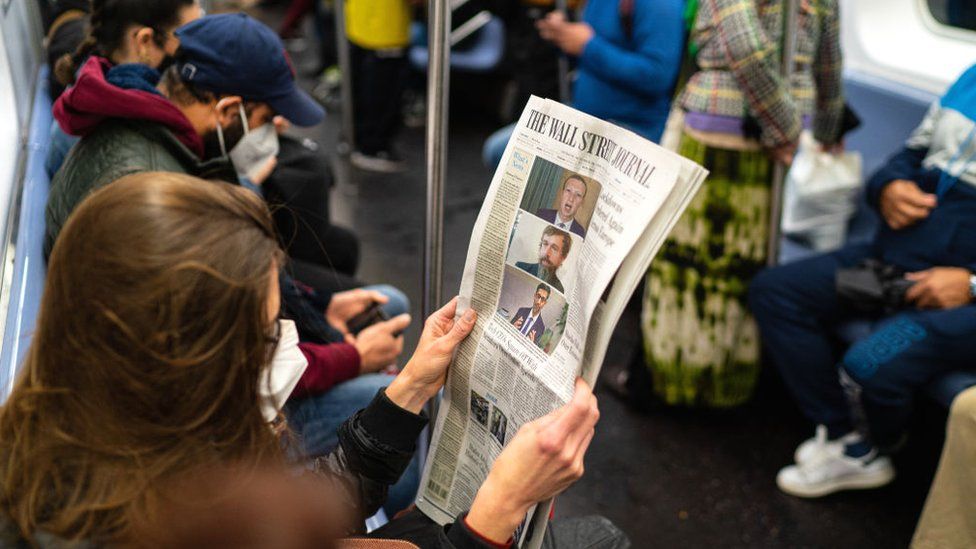 A passenger reads the front page of the Wall Street Journal reporting on tech company executives testifying to a congressional committee investigating monopoly policies on October 29, 2020