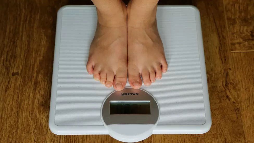 Feet on a set of weighing scales