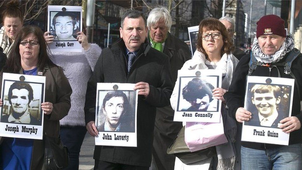 Families of those killed in the Ballymurphy massacre with images of their relatives