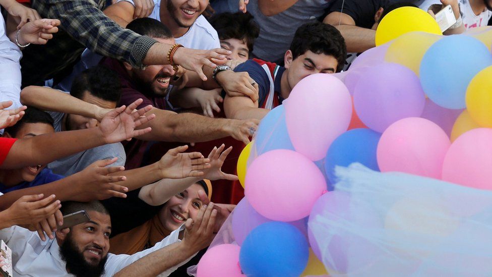 Egyptians celebrate and try to catch balloons released after Eid al-Fitr prayers, marking the end of the Muslim holy fasting month of Ramadan at a public park, outside El-Seddik Mosque in Cairo, Egypt June 25