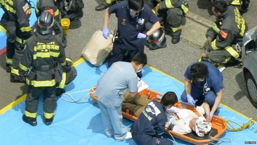 A passenger in treated by medics and rescue workers after escaping the train (30 June 2015)
