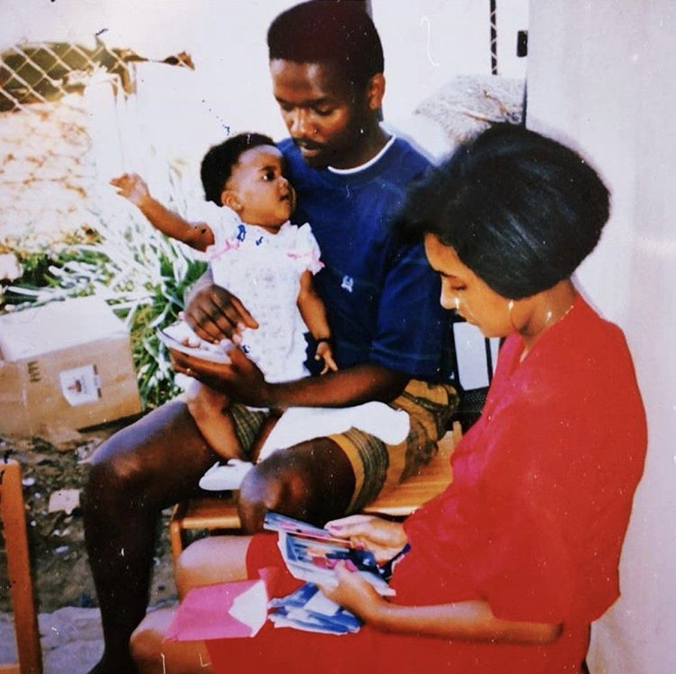 A picture of Candice Mama as a baby with her mother and father