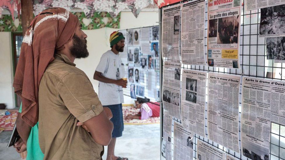 Men look at old newspaper clippings as part of the 30th anniversary ceremonies in tribute to victims of the 1988 hostage crisis, on Ouvea island, New Caledonia