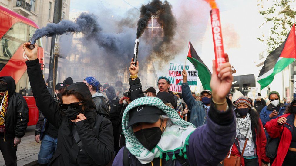 Demonstrators in central London hold smoke flares as they protest in solidarity with Palestinians in Gaza