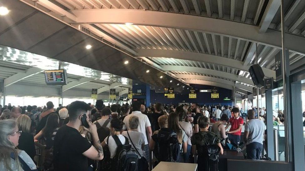 passengers queuing at Stansted Airport