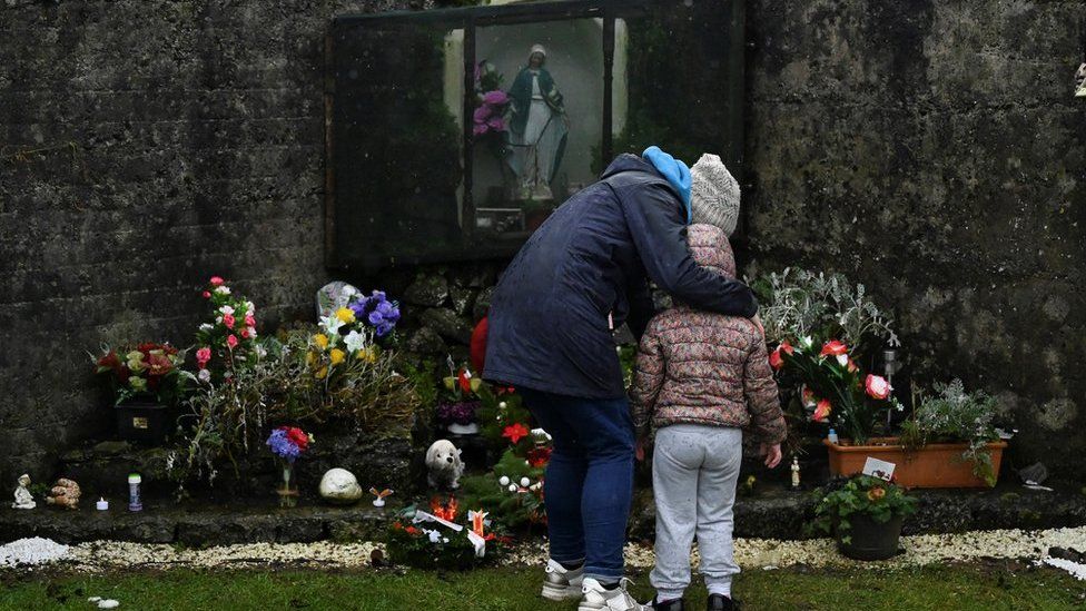 A mother and her daughter pay their respects at the Tuam graveyard where the bodies of 796 babies were uncovered