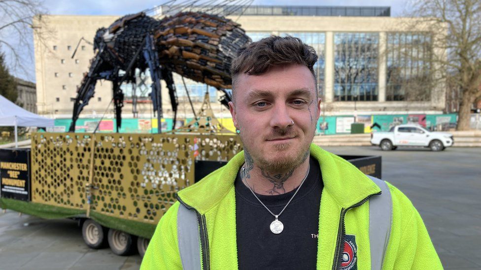 Riley Stevens stood by the bee sculpture made out of knives and guns in Kings Square, Gloucester