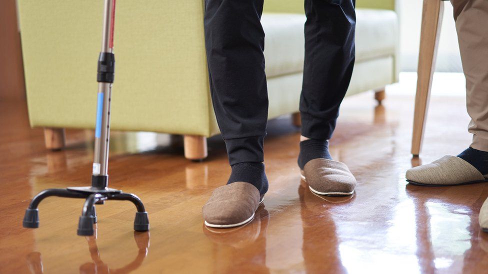 Stock image of an elderly person using a walking cane