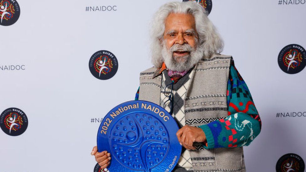 Jack Charles holding a Naidoc award