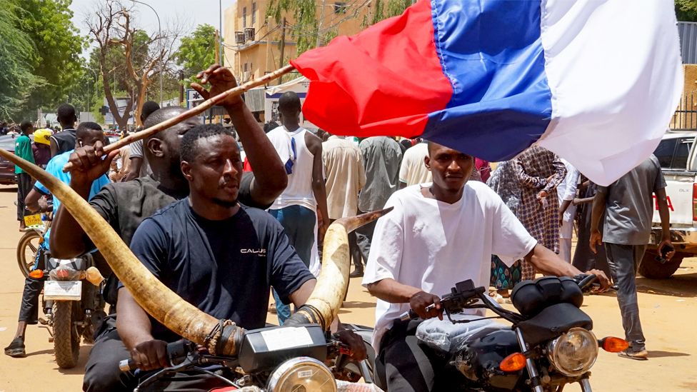 Protesters on motorbikes carry a Russian flag during a protest in Niamey, Niger, on 30 July 2023