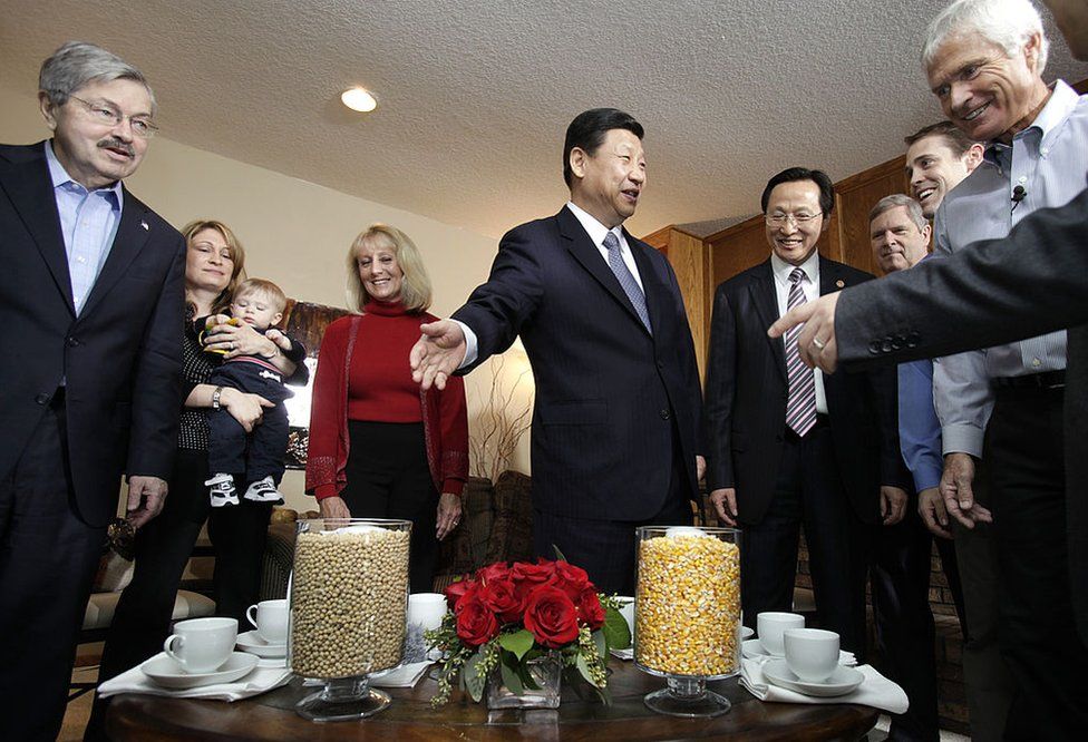 Mr Xi looks at vases full of soybeans and corn in the Kimberly home in 2012 as Mr Branstad and Mr Kimberley look on