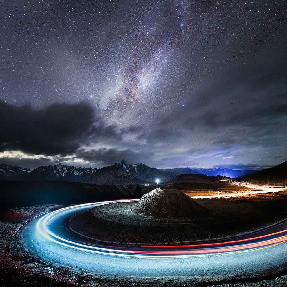An image of the night sky and a long exposure shot of a car driving around a mound of rock