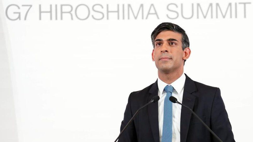 Rishi Sunak standing behind a podium at the G7