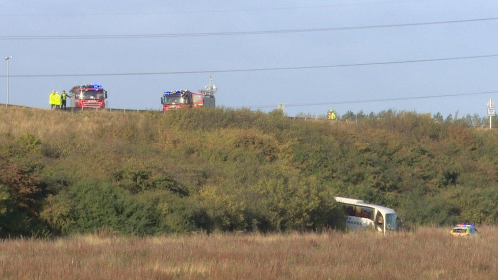Bus crashes down A1 embankment BBC News(01)