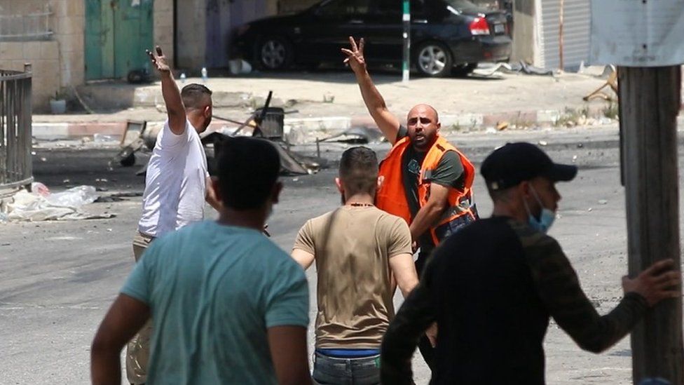 A second video filmed by a journalist outside al-Amal hospital in Jenin shows a paramedic rushing to Abdul Rahman Hardan and picking him up before carrying him along the street (4 July 2023)
