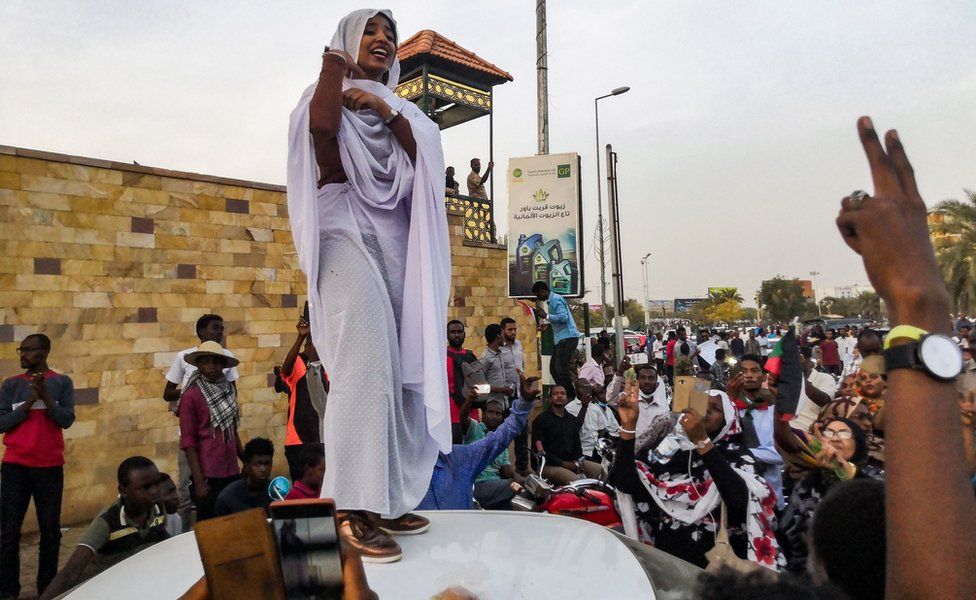 Alaa Salah, a Sudanese woman propelled to internet fame earlier this week after clips went viral of her leading powerful protest chants against President Omar al-Bashir, addresses protesters during a demonstration in front of the military headquarters in the capital Khartoum on 10 April 2019